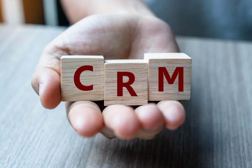 Business woman hand holding wooden cube with CRM text